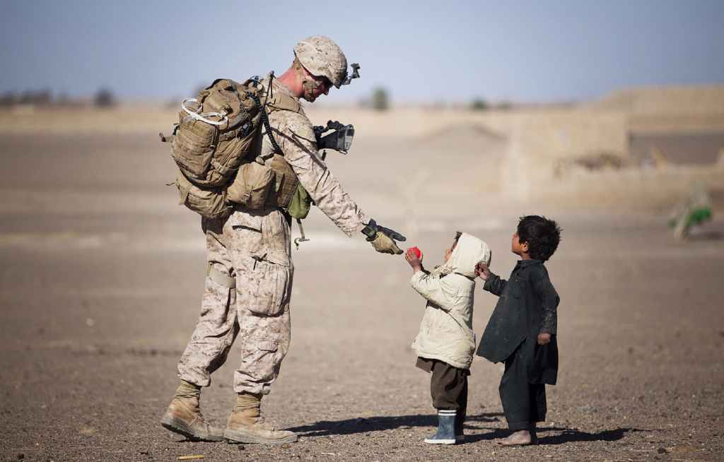 The image shows children giving a gift to a soldier. 5 Heart-warming Reasons Why Performing Acts of Kindness is Good For You.